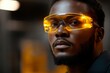 © c80 - Young man wearing yellow-tinted safety glasses poses in a workshop setting during late afternoon