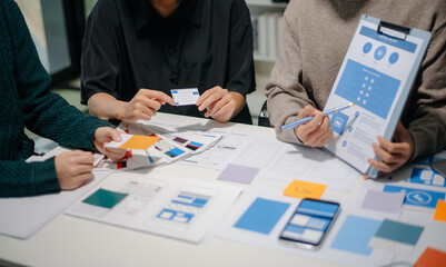 Wall Mural - close up view of ui developer team brainstorming on their project with laptop, smartphone and digita
