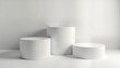 © Viktor - Minimalist presentation podiums in various heights. Simple white cylinders on white background. Versatile display for product presentation. Modern, clean design. Ideal for diverse product types.