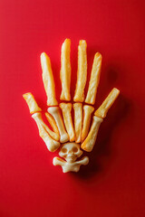 Fried Anatomy: Creative Skeleton Hand Design with French Fries on Vibrant Red Background