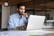 © fizkes - Indian businessman staring at laptop screen deeply focused on his work seated in workplace, analyze received document, review data, consider decision, working on financial report and business strategy