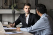 © fizkes - Two businessmen discussing deal or project progress, negotiate contract terms, planning future collaboration or business opportunities, analyzing market research data met in company office with laptop