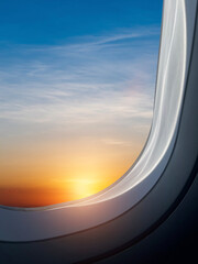 Wall Mural - Airplane flying low over foggy mountains, view from plane window of plane wing and sky sunrise