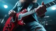 © familymedia - A musician rocks a red electric guitar under vibrant stage lights, delivering an exciting and energetic performance with a focus on powerful musical expression.