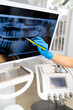 © Vadim - Dentist reviews X-ray for diagnosis. A dental professional examines a dental X-ray on a monitor while discussing treatment options in a clinic.