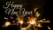 © 24K-Production - Burning sparklers with beautiful sparks on a dark background with Happy New Year text.