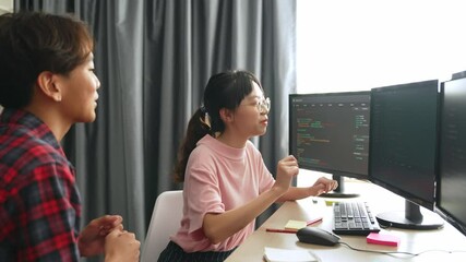 Slow motion back end software developer engineer for computer programming working together on debugging writing computing code, solving complex algorithms display on monitor in office. Burgeoning
