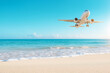 © azurita - A small white airplane is flying over a beach