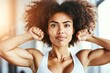 © Konstiantyn Zap - Strong african female young adult with curly hair flexing muscles in activewear