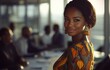 © Music_A - A detailed shot of a happy young African businesswoman smiling, while her colleagues conduct a meeting in the background