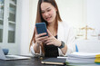 © NanSan - A young, professional businesswoman working at her desk in an office, providing online legal consultancy for disputed civil cases, addressing lawsuits, loan defaults, unfair dismissals, and property
