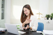 © NanSan - A young, professional businesswoman working at her desk in an office, providing online legal consultancy for disputed civil cases, addressing lawsuits, loan defaults, unfair dismissals, and property