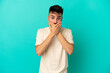 © luismolinero - Young caucasian man isolated on blue background covering mouth with hands