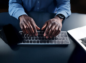 Aufkleber - Close-up of dark-skinned hands typing on a keyboard at night.  Low light illuminates the scene, emphasizing the focus on the typing process. A laptop is visible to the side.
