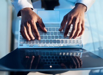 Aufkleber - Close-up view of hands actively typing on a laptop keyboard. The image focuses on the hands and the keyboard, suggesting work, digital engagement, or online activity.  The laptop is light-colored with