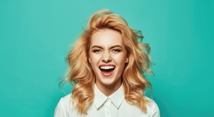 Wall Mural - Cheerful caucasian young female with blonde hair against teal background