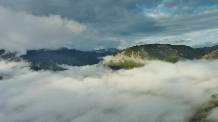 Wall Mural - flying between the clouds. aerial view of clouds and mountains at sunrise, panorama 4k
