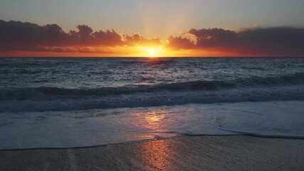 Wall Mural - stunning sunset over sea with vibrant colors reflecting on the water at the beach, 4k