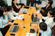 © InfiniteFlow - Group of happy businesspeople in celebratory gesture and successful efficient teamwork. Diverse race office worker celebrate after made progress on marketing planning in corporate office. Habiliment