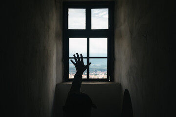 silhouette of a man's hand on the background of a old vintage castle window with view of mountains t