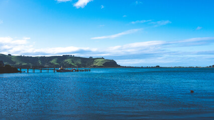 Wall Mural - Beautiful ocean sea scenes clear day calm water blue sky Otago peninsula Dunedin New Zealand boats jetty dingy 