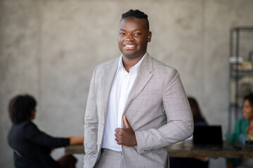 Leinwandbilder - A confident business professional stands in an office environment, engaging with colleagues.