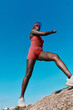 © SHOTPRIME STUDIO - Athletic woman climbing on a rock against a clear blue sky, showcasing determination and strength