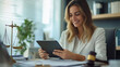 © AspctStyle - Smiling female lawyer working on a tablet at her desk with scales of justice in the background. Legal and professional concept