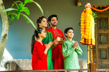 Happy Indian family in ethnic attire performing Gudi Padwa puja, a Hindu New Year celebration