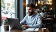 © DWIJ - Businessman on a laptop during work in a cafe. Concept of remote and freelance work.