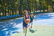 © Blue Jean Images - Chinese Kids Playing Basketball on Basketball Court