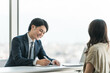 © buritora - 面談・面接を行うビジネスマンと面接を受ける女性