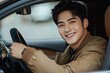 © ffunn - Handsome young man driving his new car, sitting in the driver's seat and smiling at the camera