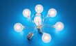 © ANUAR - Artistic Arrangement of Light Bulbs with a Central Illuminated Bulb Against a Bright Blue Background, Symbolizing Innovation and Creative Ideas