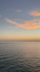 Wall Mural - Sunset sky over the calm ocean, vertical video.