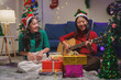 © crizzystudio - Group of young Asian friends celebrate Christmas Eve enjoying singing and playing guitar at a house party..Have fun while having fun clapping together in happiness, cheerfulness, celebration concept.