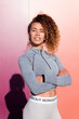 © Raul Mellado - self confident latin female athlete in sportswear with folded arms looking at camera on colorful background, concept of sport and healthy lifestyle, copy space for text