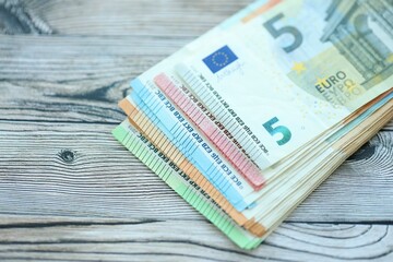 Big amount of different denominations of euro money bills on wooden background