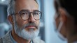 © liliyabatyrova - A middle-aged man with glasses and a beard listens intently during a heartfelt discussion. The bright indoor space enhances the connection between the two individuals