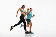 © master1305 - Low angle side view image of young athletic woman and muscular man in motion, training, running against white studio background. Concept of sport, active and healthy lifestyle, workout, fitness