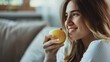 © iuricazac - A woman with long blonde hair and a white shirt is smiling while holding an apple in her hand.