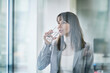 © Westend61 - Mature businesswoman drinking glass of water in office
