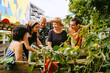© Westend61 - Small group of people socializing and gardening in an urban community garden.