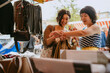 © Westend61 - Two young women shopping at a flea market outdoors during the daytime.