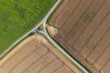 © Westend61 - Aerial view of agricultural fields with small road junction directly from above, summer. Franconia, Bavaria, Germany, Europe.