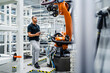 © Westend61 - Technician examining industrial robot in a factory