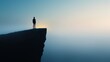 © daniel - Person standing on cliff edge at dawn overlooking fog-covered landscape