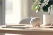 © khalid_spk - piggy bank minimalistic desk setting modern decor pen and paper plant neutral color palette soft lighting home office atmosphere