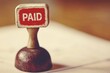 © stock.metket.com - Close-up of a red 'PAID' stamp vintage rubber stamp financial document focus on the stamp
