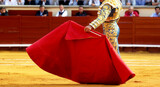 Spanish bullfighting tradition with matador holding red cape in arena